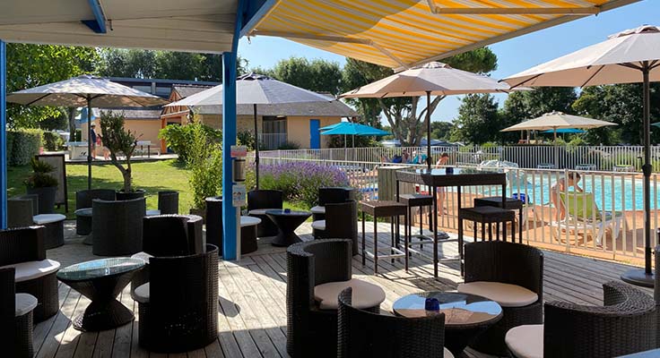 La terrasse de la piscine extérieure du camping 4 étoiles le Helles